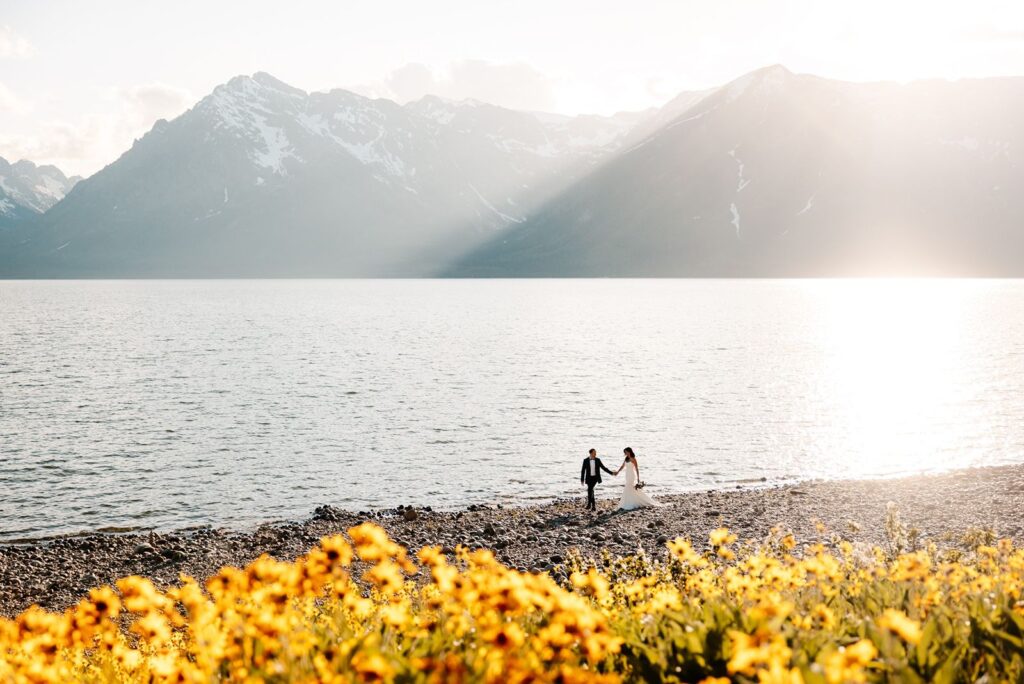 Bride and groom on beach at Coulter Bay in Tetons.